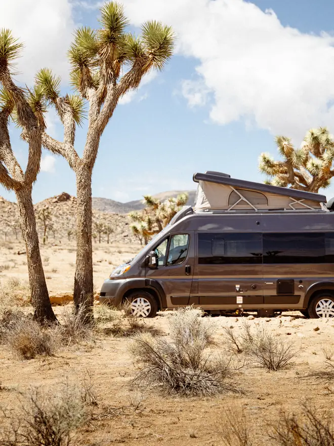 Um motorhome Classe C estacionado entre as rochas em Joshua Tree, durante um road trip de motorhome saindo de Los Angeles