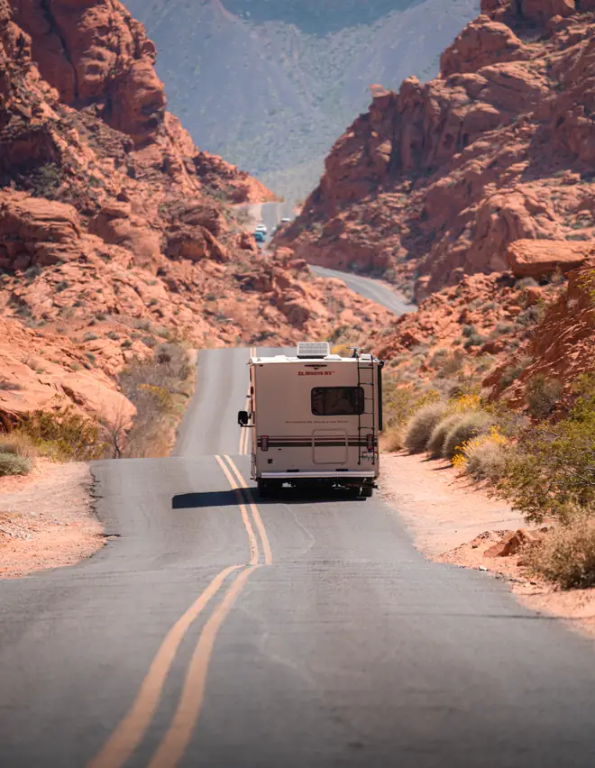 Um motorhome em uma estrada aberta no deserto, durante uma road trip só de ida pela Califórnia partindo de Los Angeles