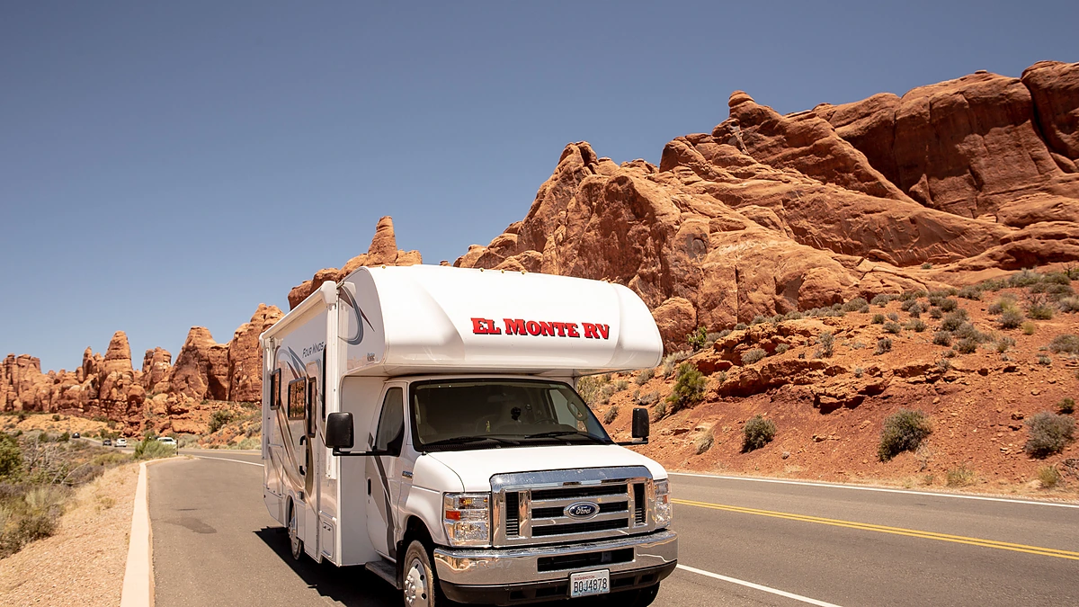 Um motorhome Road Bear Classe C estacionado entre as formações rochosas vermelhas e aconchegantes do Parque Nacional de Joshua Tree, próximo a Los Angeles