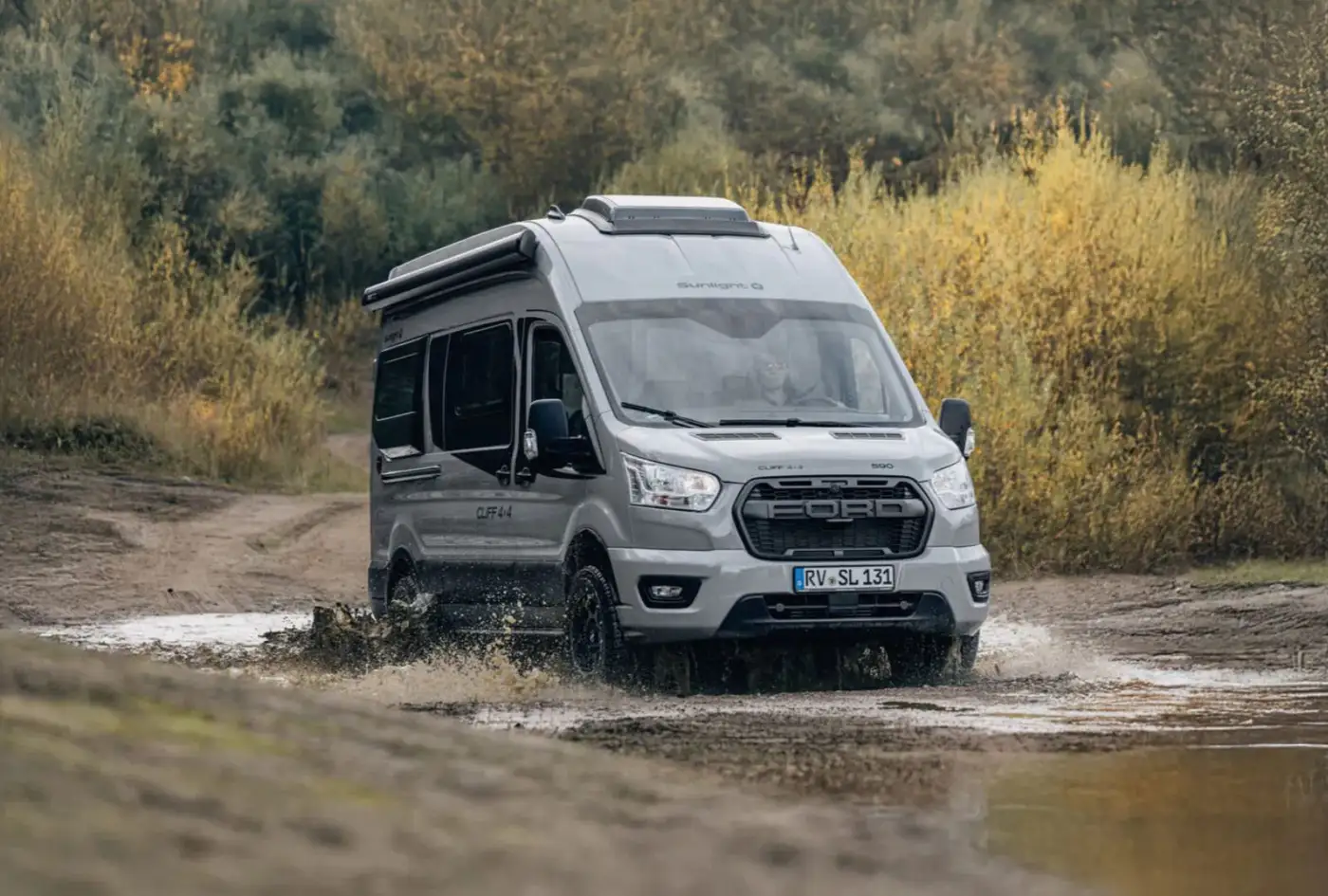 Sunlight Cliff 590 4x4 macera kamp aracı, bir arazi yolunda çamurda ilerliyor